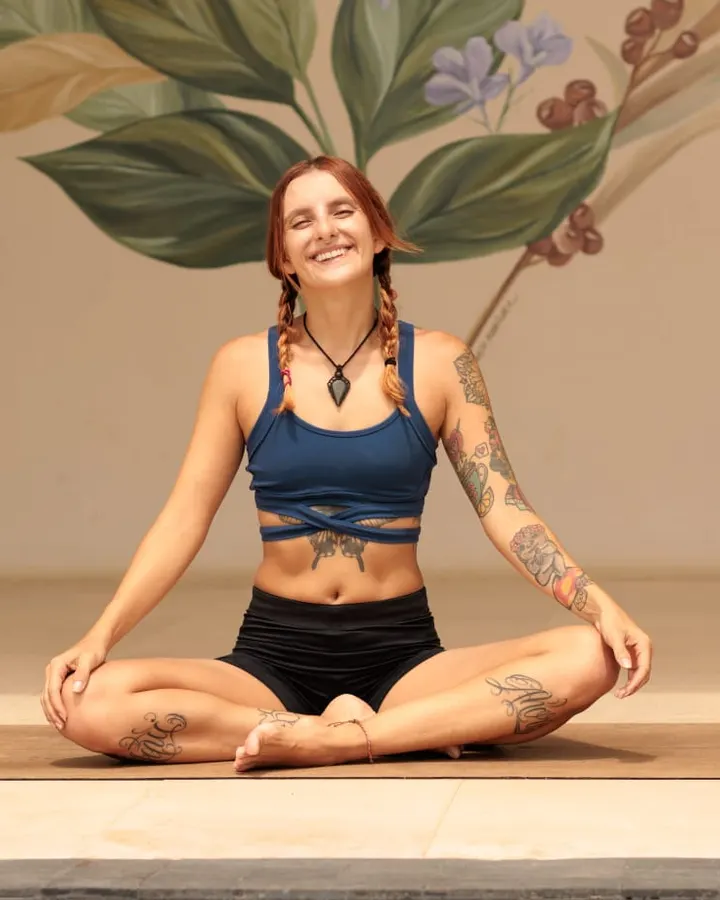 Rebeca Espinoza sentada sobre un mat de yoga